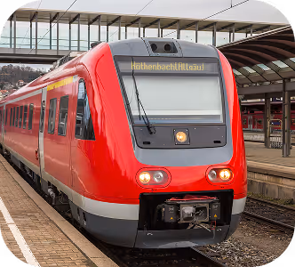 Roter Regionalzug mit Zielanzeige an einem Bahnhof mit Bahnsteig und Überdachung.